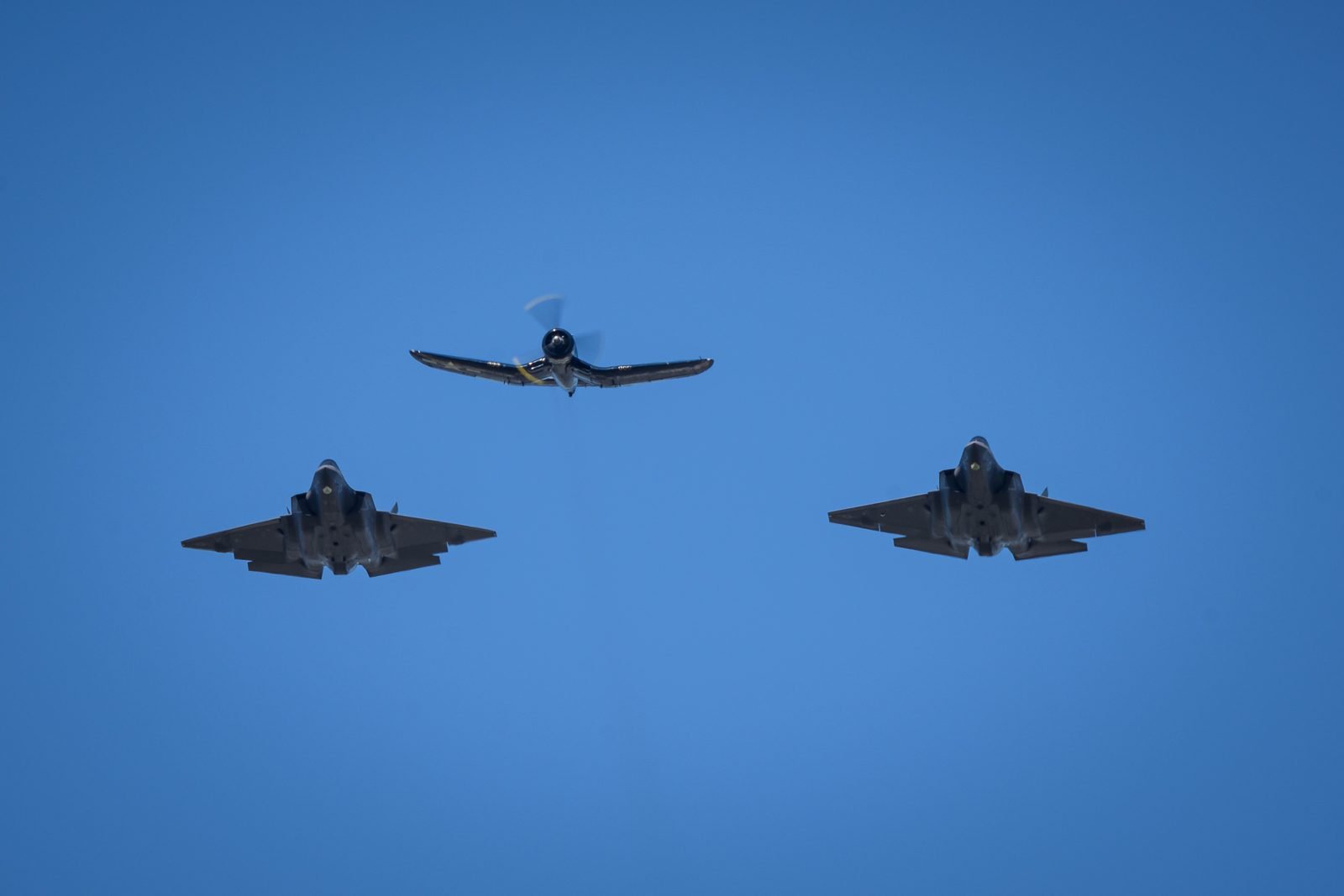 Two fighter jets crossing paths mid-air